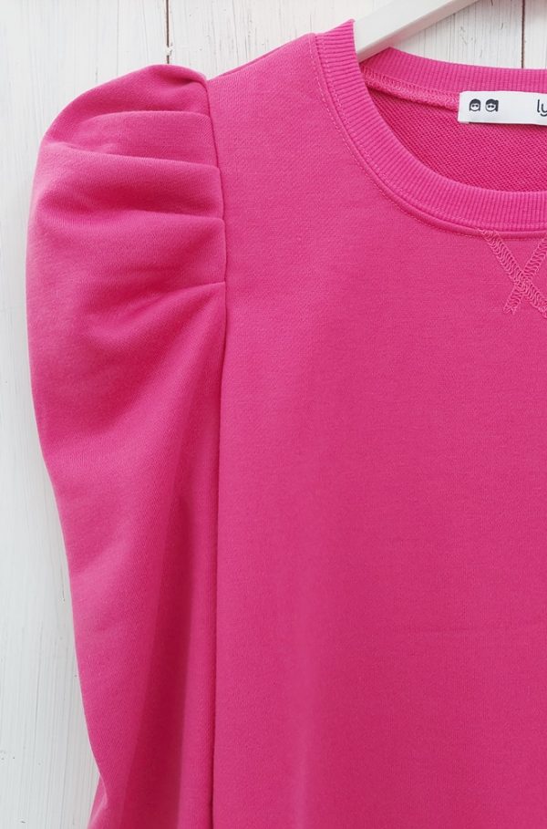 Camiseta rosa San Francisco de Lylu con mangas largas abullonadas. Cuello redondo con detalle decorativo. Una prenda básica con un toque de distinción.