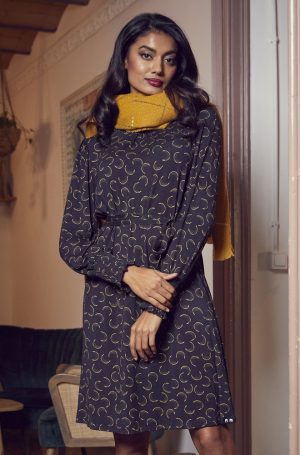 Vestido estampado Arley de Lylu con corte evasé, en color negro con estampado circular dorado. Lleva mangas largas abullonadas y puños fruncidos, que le dan un aire romántico y sofisticado, perfecto para cualquier ocasión especial. Viene con un cinturón del mismo tejido que te permite ajustarlo a tu cintura para realzar tu figura, o puedes llevarlo suelto para un estilo más relajado. Es la prenda ideal para brillar con elegancia y estilo esta temporada.