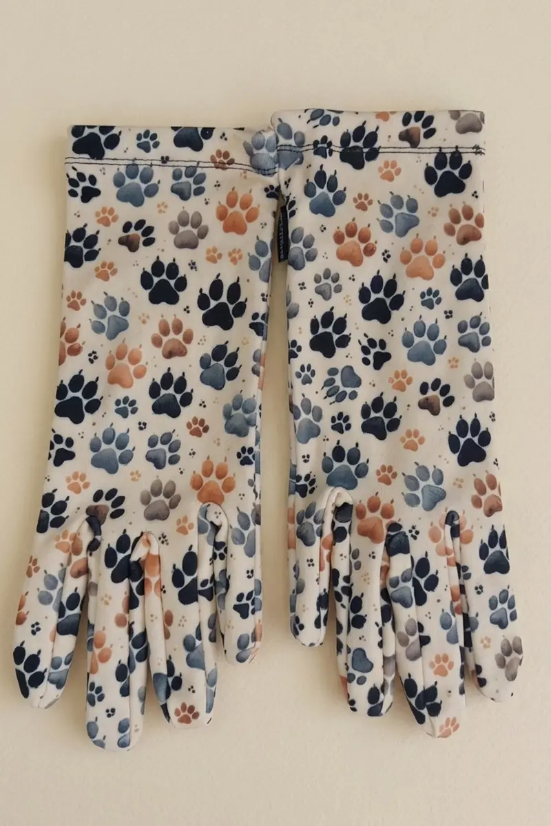 Guantes de mujer estampados Tepo de Attaversiamo en color crema con huellas negras, grises y tostadas, vista frontal